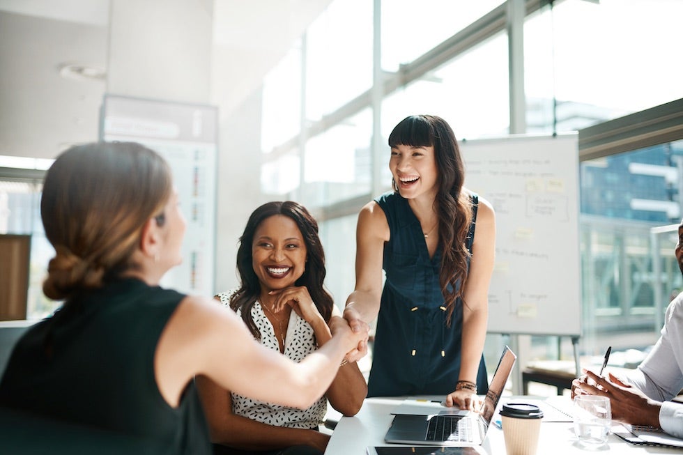 Shot of colleagues shaking hands in a meeting