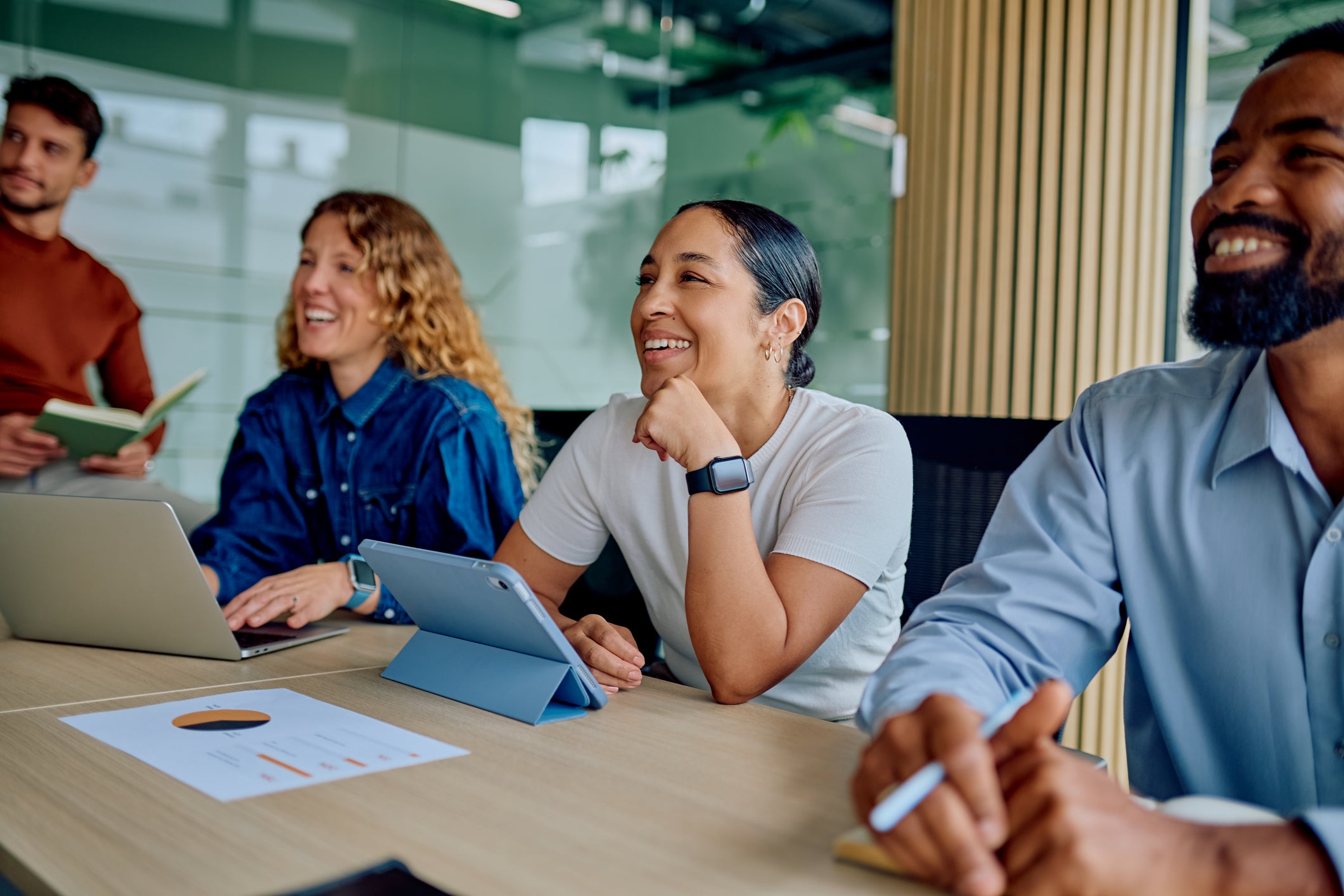 Diverse business professionals collaborating in a modern office, enjoying a productive discussion in a corporate environment